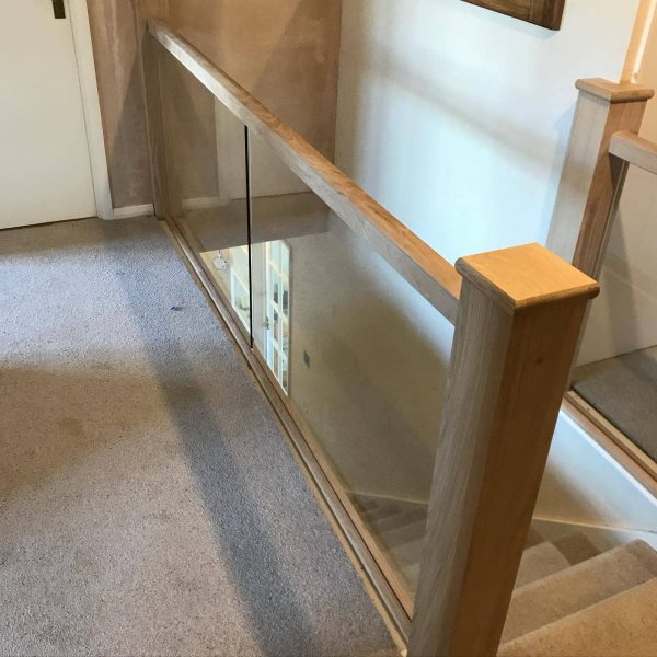 Staircase Refurbishment Southampton 56 Glass balustrade panels with oak handrail and newel posts on a landing
